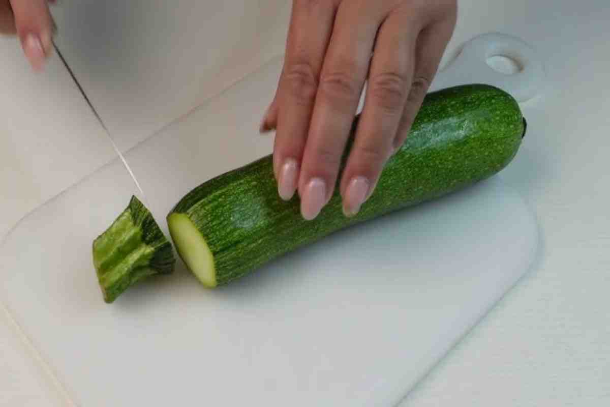 donna taglia una zucchina