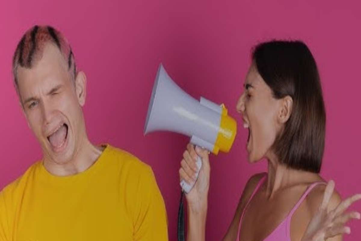 donna urla in un microfono alla persona affianco